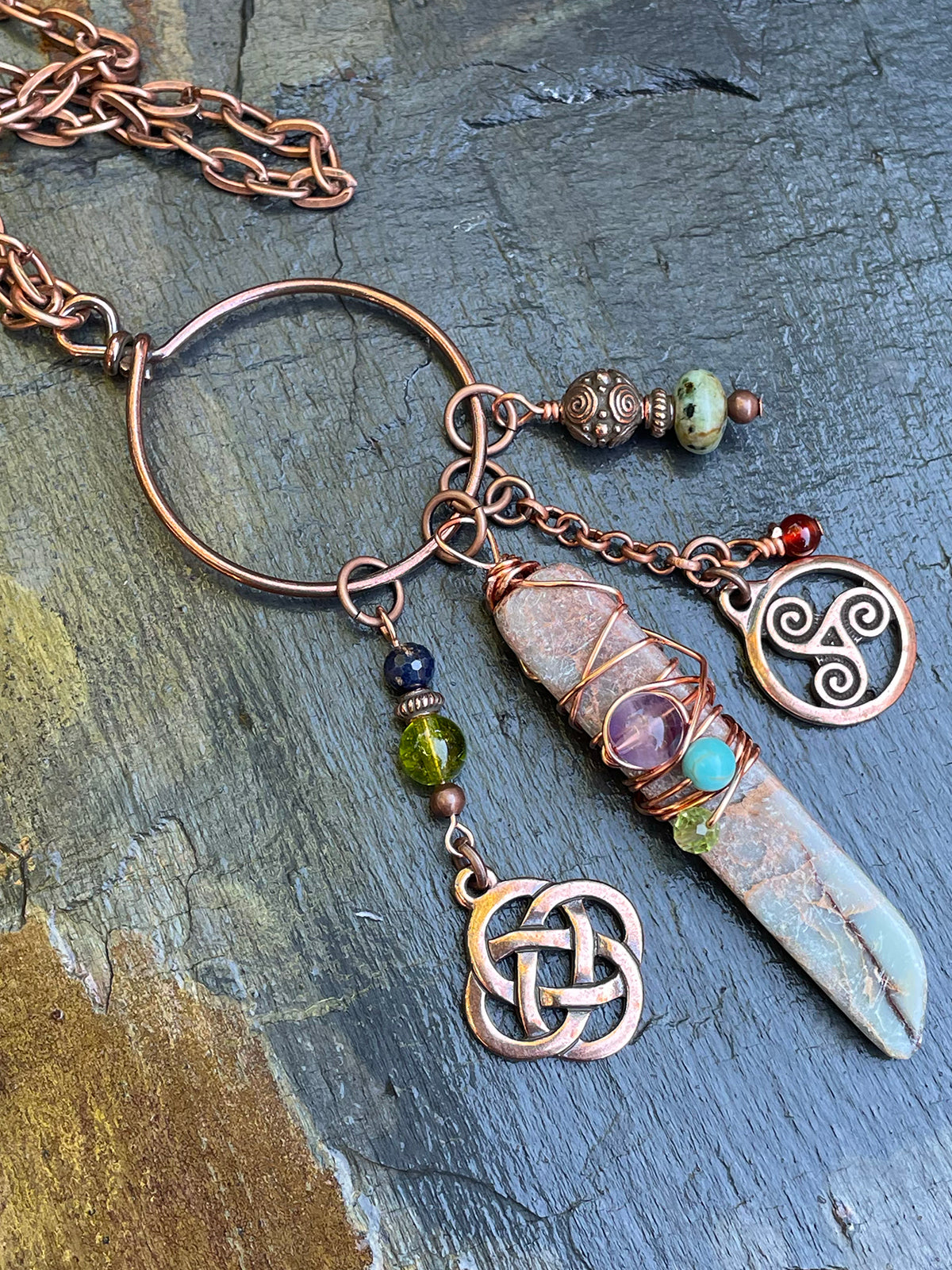 Red copper metal with gemstones that include peridot, carnelian, amethyst, turquoise and amber, the gemstone of the goddess Danu.